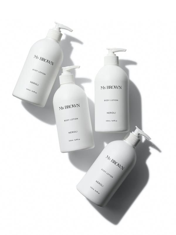 Three bottles of Ms Brown Neroli Body Lotion on a white surface.