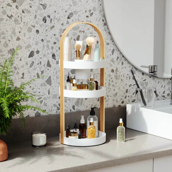 Umbra Bellwood cosmetic organiser on a vanity beside a round mirror and plant