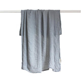 A Bamboo Blend Swaddle - Mist made by Bengali Collections hanging on a clothesline.