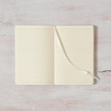 An open Morning Pages — Journal on a wooden surface. (Brand Name: Thought Catalog)