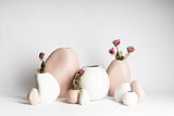 A group of Harmie Vase - Various Options from Ned Collections pink and white vases on a white surface.