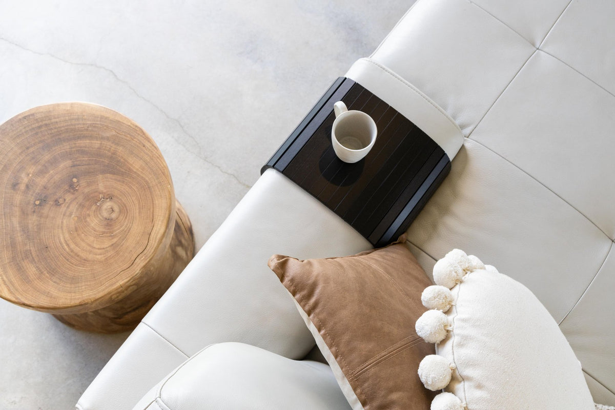 Ned Collections armchair side rest tray in a pale finish on a sofa arm beside cushions and a coffee table