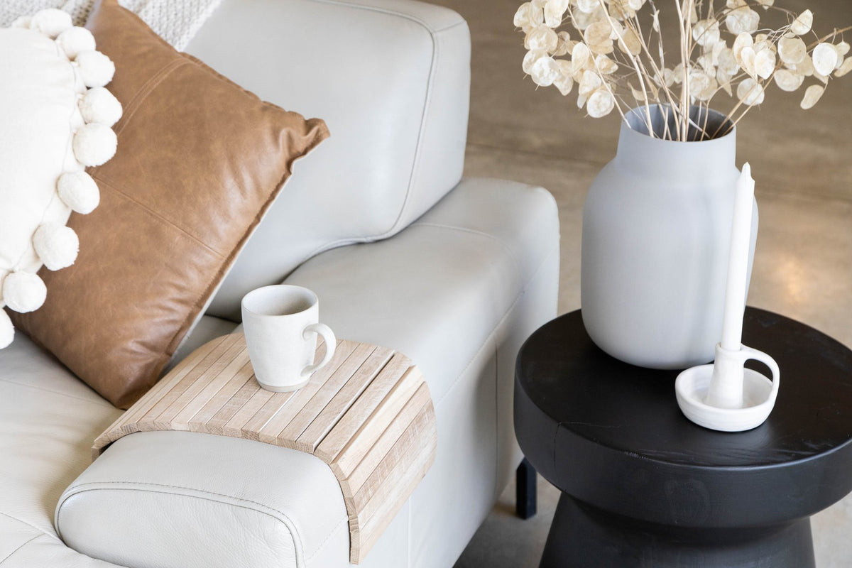 Ned Collections Arm Chair Side Rest in a living room beside a coffee table