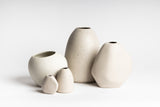 A group of Ned Collections HARMIE Pebble Vases - Natural, hand-crafted by Vietnamese Artisans, on a white surface.