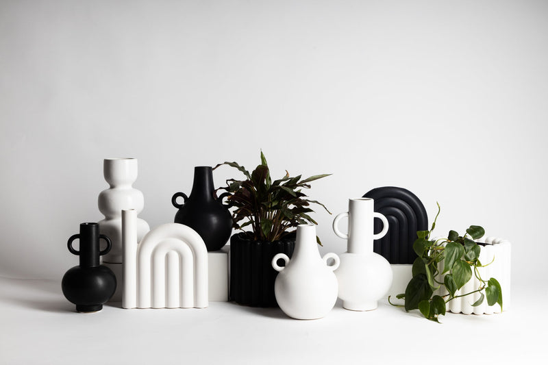 A group of elegant Ned Collections HAROLD VASES with a matte finish on a white surface.