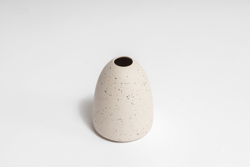 The HARMIE Pebble Vase - Natural, hand-crafted by Vietnamese artisans, is a stunning white vase with a unique hole design.