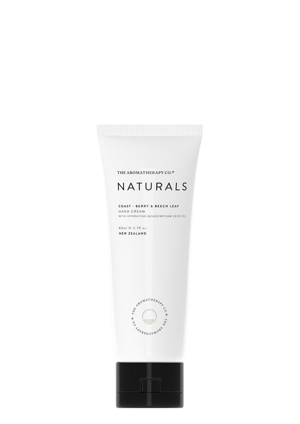 The tube of Naturals Hand Cream Coast - Berry & Beech Leaf by The Aromatherapy Co, enriched with Meadowfoam Seed Oil, showcases its antioxidant and protective properties. Set against a sleek black background, the hand cream's captivating berry aroma and nourishing attributes are on display.
