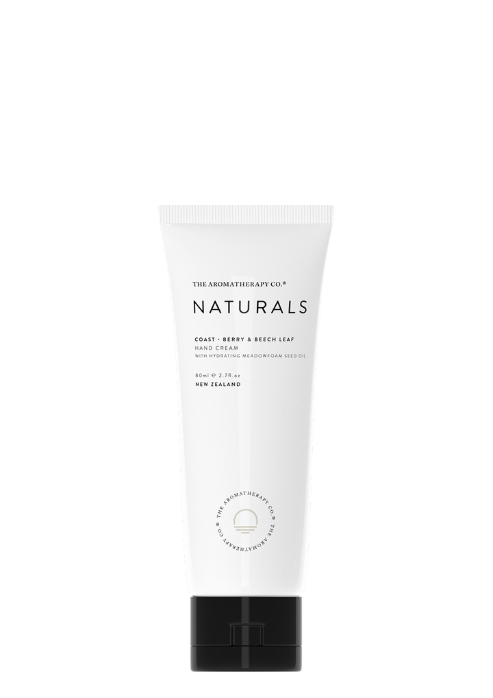 The tube of Naturals Hand Cream Coast - Berry & Beech Leaf by The Aromatherapy Co, enriched with Meadowfoam Seed Oil, showcases its antioxidant and protective properties. Set against a sleek black background, the hand cream's captivating berry aroma and nourishing attributes are on display.