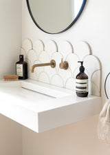 A bathroom with a white sink and a mirror from Our Spaces - Contemporary New Zealand Interiors Books.