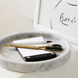 A Papier HQ Marble round tray with a pen and a notepad.