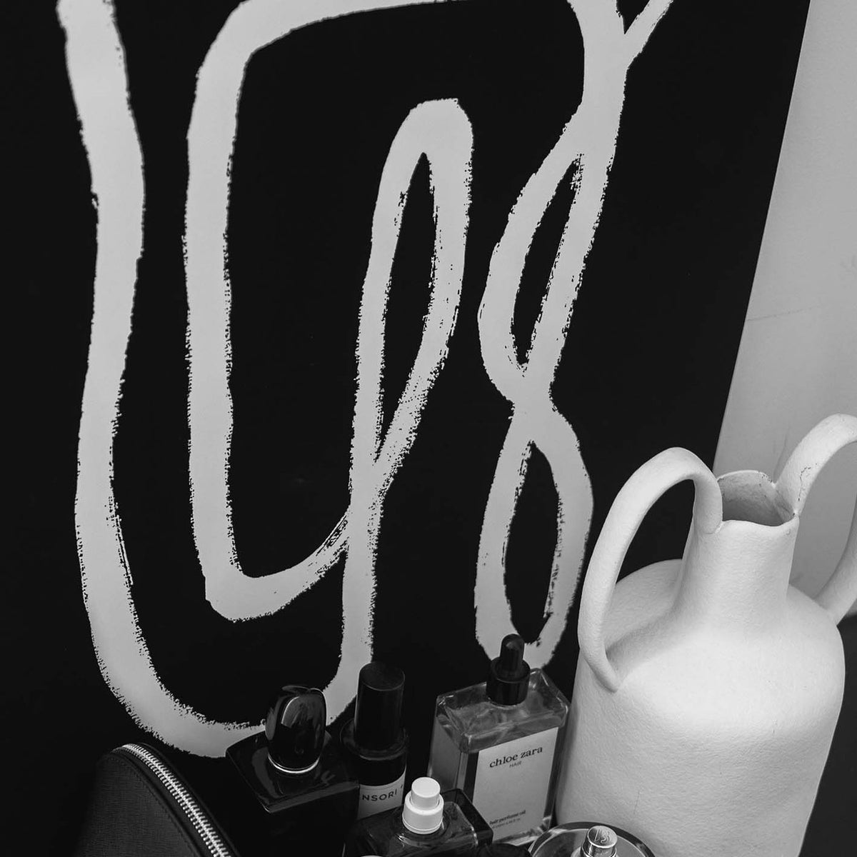 An artistic PAPIER HQ | LINKED PRINT BLACK of a bottle of perfume on a table, perfect for framing.