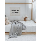 A cozy bed adorned with a teddy bear and a sign that says you are my sunshine, featuring Bengali Collections' Oeko-tex® Certified Cotton bedding.