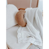A White Heirloom Blanket with a teddy bear on it by Bengali Collections.