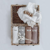 A wicker basket with a set of Bengali Collections White Heirloom Blanket in it.