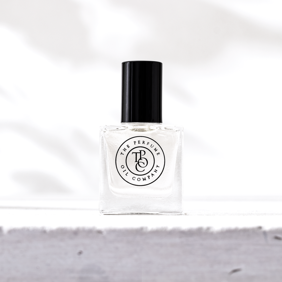 Perfume oil bottle on a grey stone ledge, seen from slightly lower