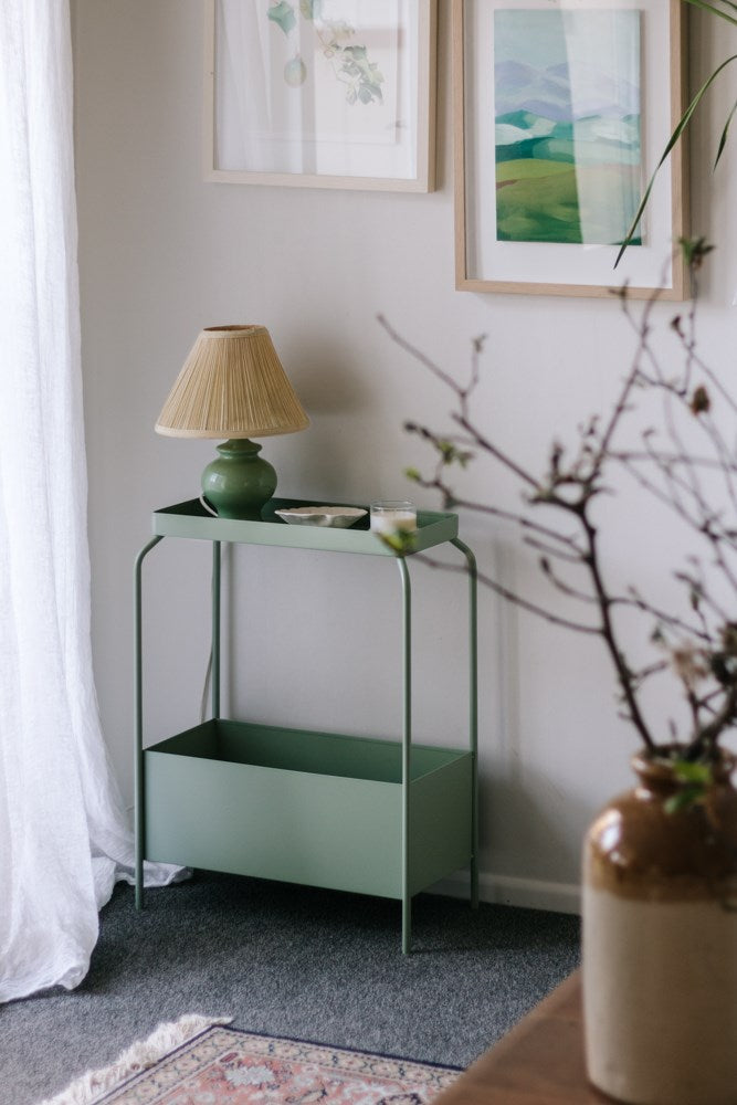 A living room with a Garcia Home Metal Planter Stand - Various Options and a lamp.