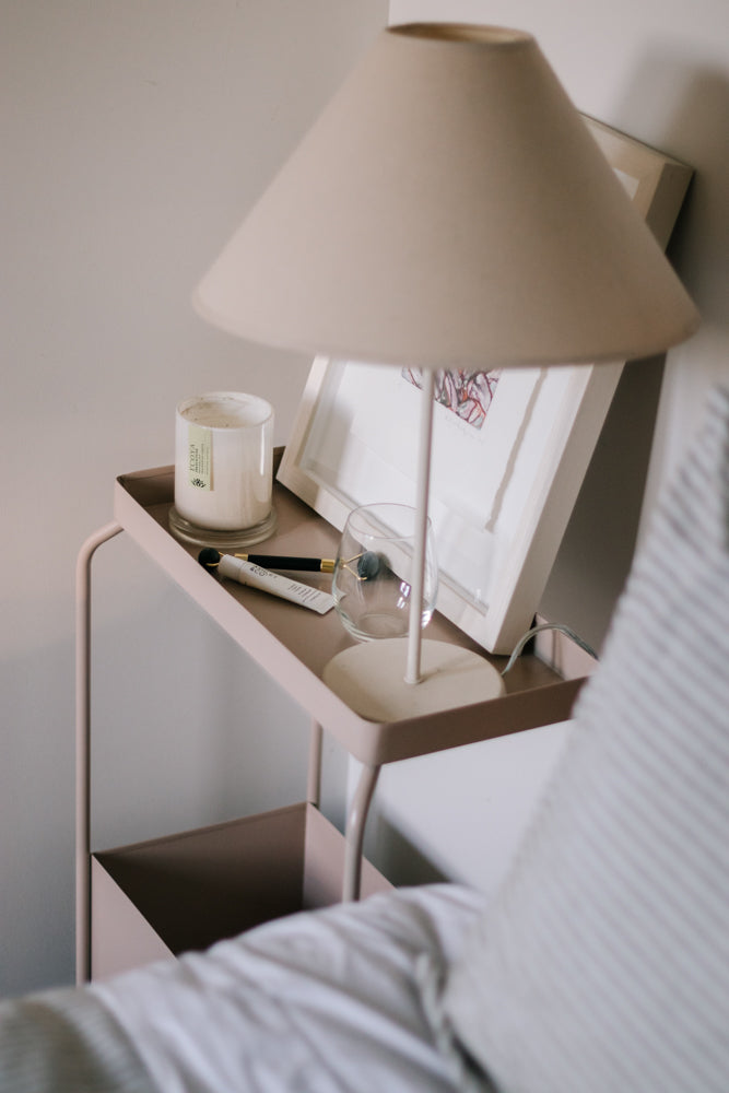 A decorative bedside table with a powder-coated lamp on it and a Garcia Home Metal Planter Stand - Various Options.