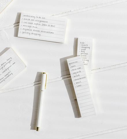 A set of Metal Rollerball Pens by Emma Kate Co featuring gold metal hardware and Butter Gingham refillable notepads on a white surface.