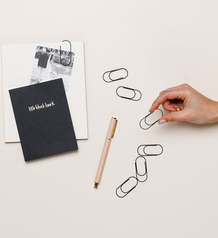Grande Paper Clips styled on a desk with notebook and pen, matte black by Emma Kate Co