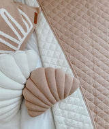 A bed with a pink and white quilt and pillows made from Oeko-tex® certified Bengali Collections SMALL SHELL CUSHION - MIST / NOUGAT.