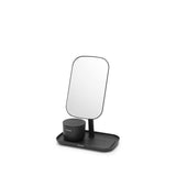 An adjustable Flux Home mirror with storage tray - Dark Grey / White sits atop a sleek white surface, serving as both a make-up essential and storage tray.