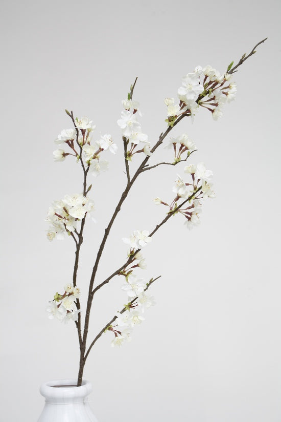 A white Cherry Blossom Spray White vase with Artificial Flora artificial plants in it.