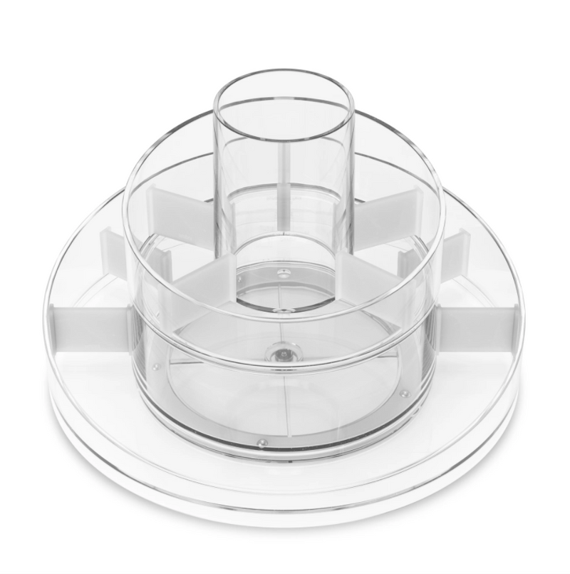 A CASCADA COSMETIC ORGANIZER by Umbra, a clear plastic bowl with a lid on top, featuring a rotating base.