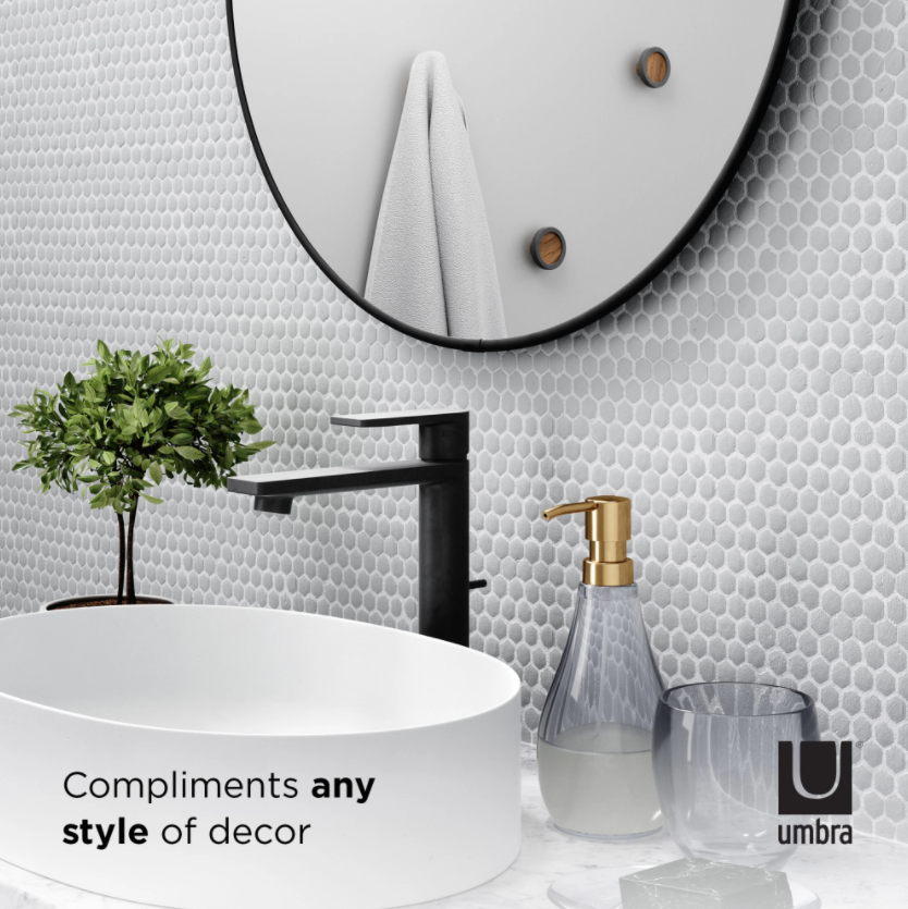 A bathroom with an Umbra Hubba Mirror 34 Titanium featuring a decorative metal frame.