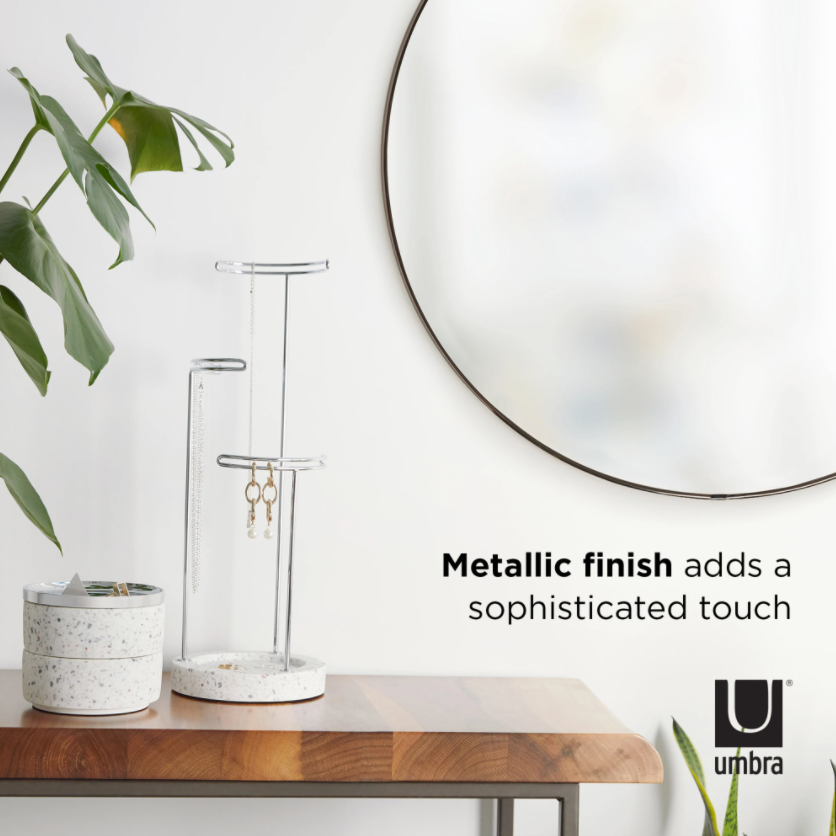 The HUBBA MIRROR 34 TITANIUM by Umbra features a decorative metal frame, adding a sophisticated touch.
