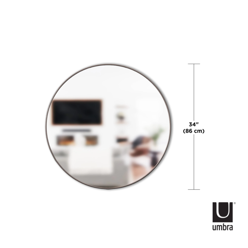 A stunning HUBBA MIRROR 34 TITANIUM with a decorative metal frame, part of the Umbra range, adds elegance to any living room.