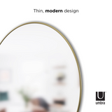 A HUBBA MIRROR 86cm BRASS with a thin modern design featuring the decorative metal frame by Umbra.