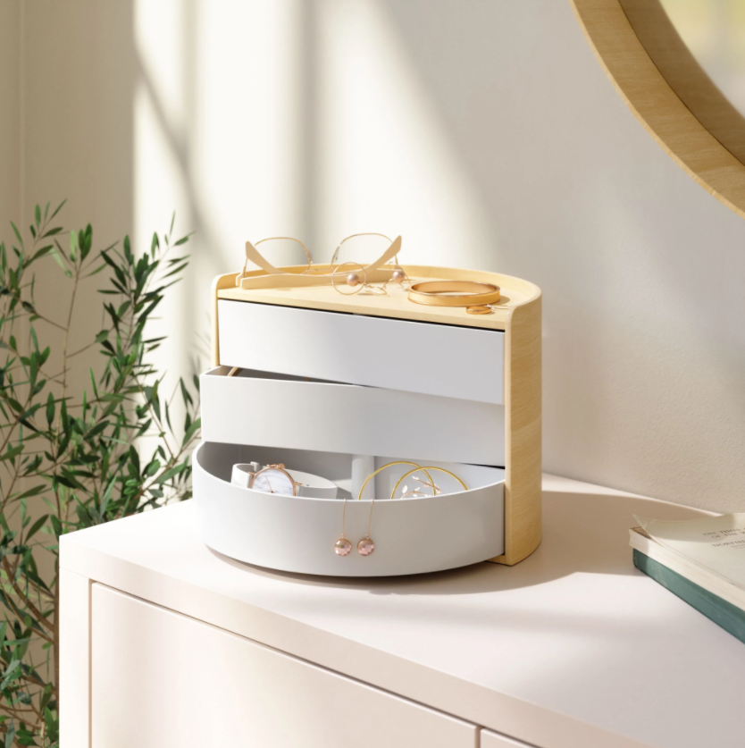 Umbra Moona storage box in white and natural on a dresser beside a mirror and greenery