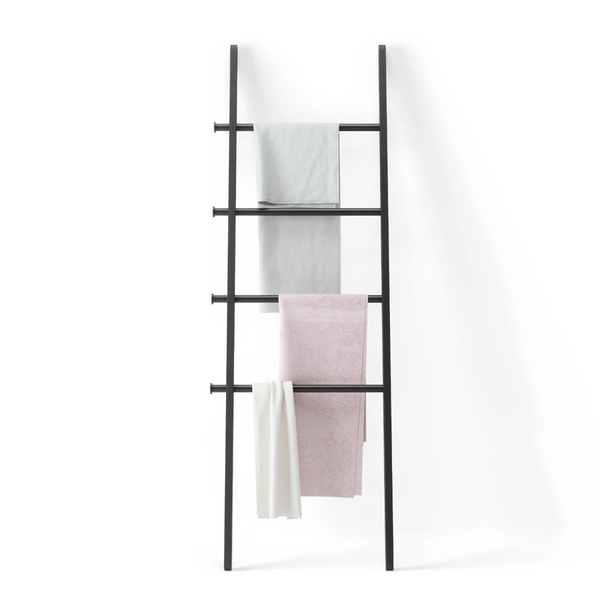 A LEANA LADDER - BLACK with Umbra towels hanging on it.