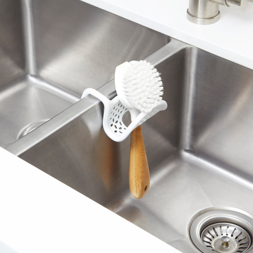 Umbra Sling sink caddy with a brush in the built-in holder