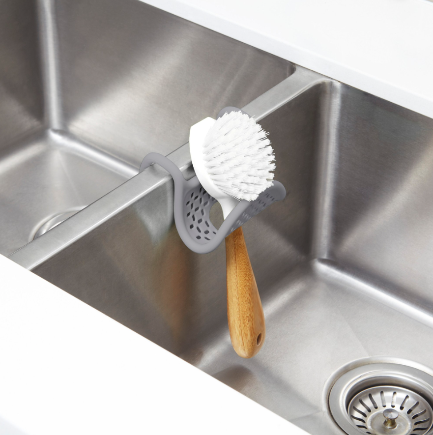 Umbra Sling sink caddy holding a scrubbing brush upright