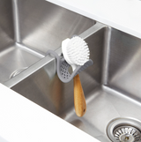 A SLING SINK CADDY with drainage and a brush. (Brand: Umbra)