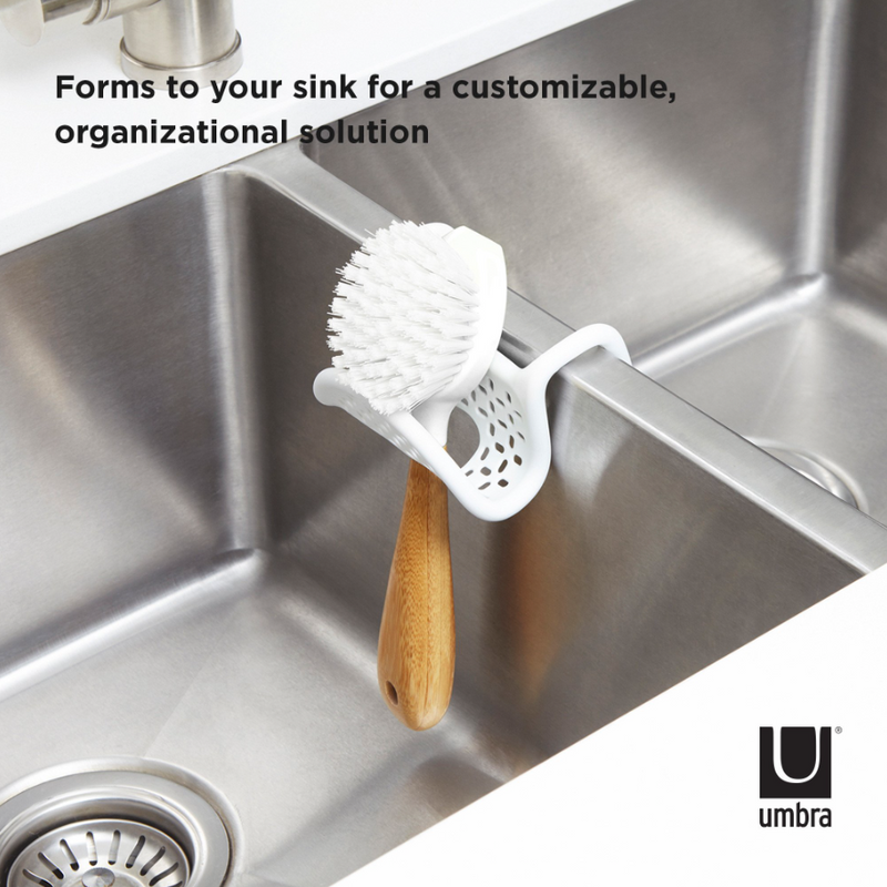 A sink with a SLING SINK CADDY by Umbra, having flexible sink caddy and non-slip properties.