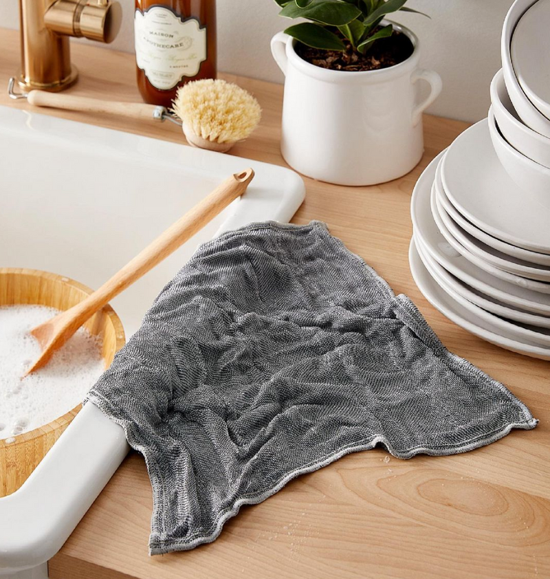 A Nawrap dishcloth with high water absorbency is sitting on a sink.