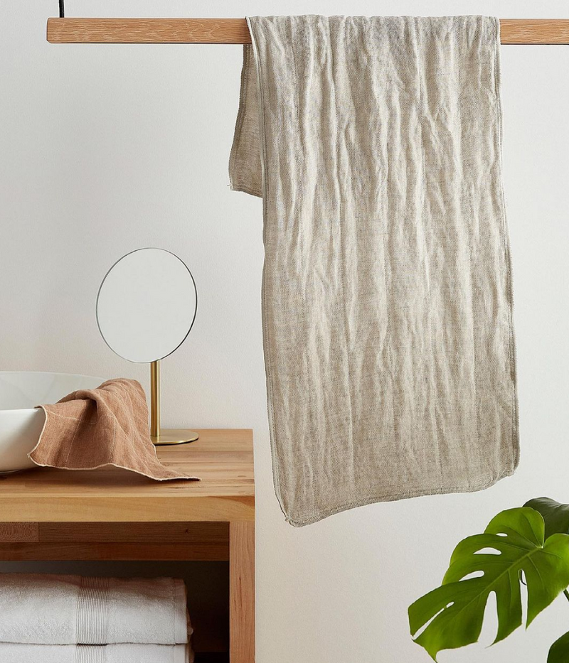 An ORGANIC FITNESS TOWEL hanging on a rod in a bathroom, made by Nawrap.