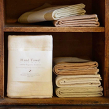 ORGANIC FACE TOWEL by Nawrap in a wooden cabinet.