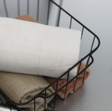 ORGANIC FACE TOWELS by Nawrap in a wire basket on a counter.