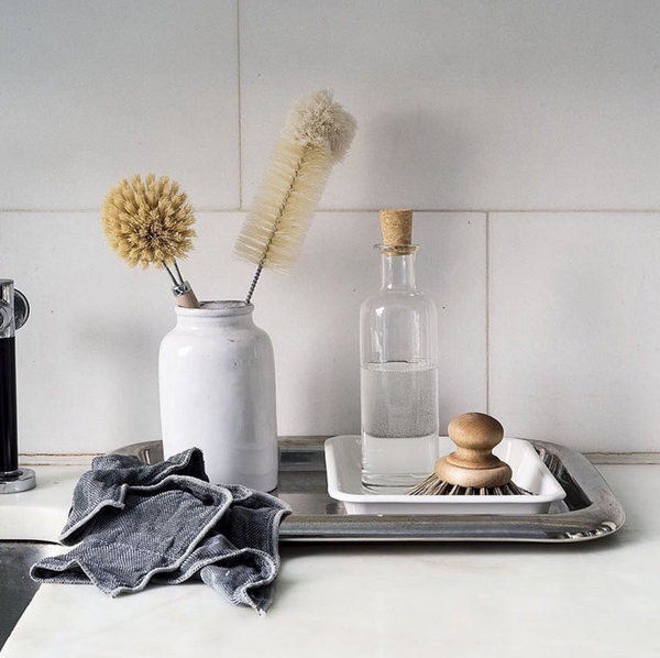 A Nawrap naturally made tray with a bottle of water and brushes on it.
