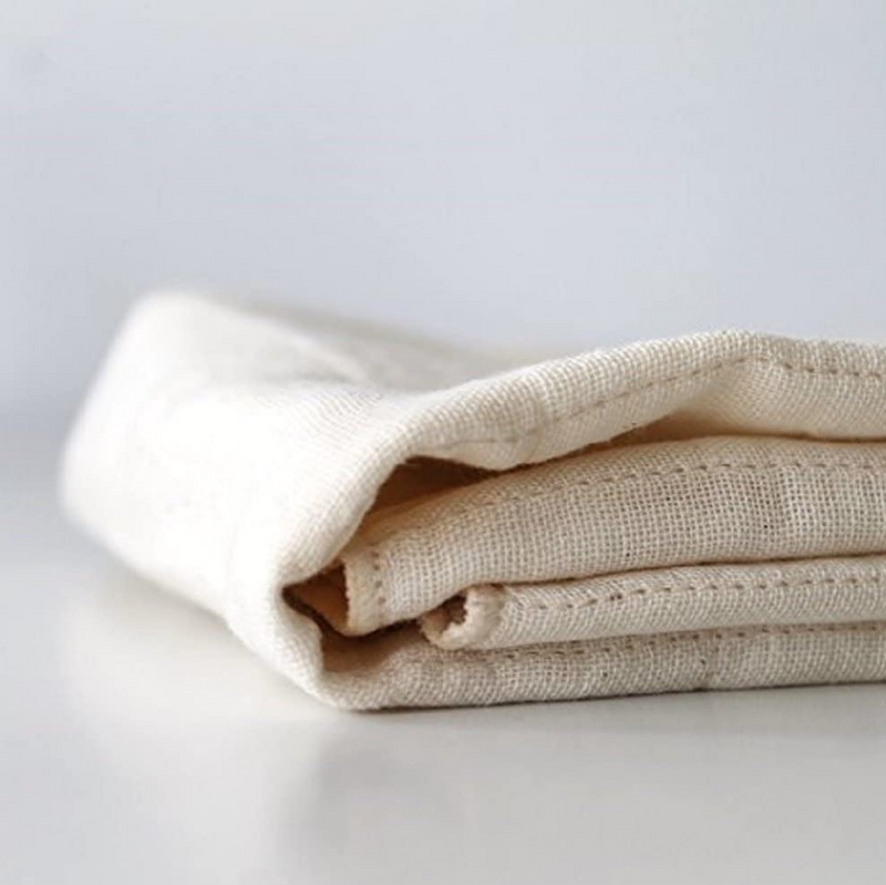An antibacterial Nawrap dishcloth delicately folded on top of a naturally made white surface.