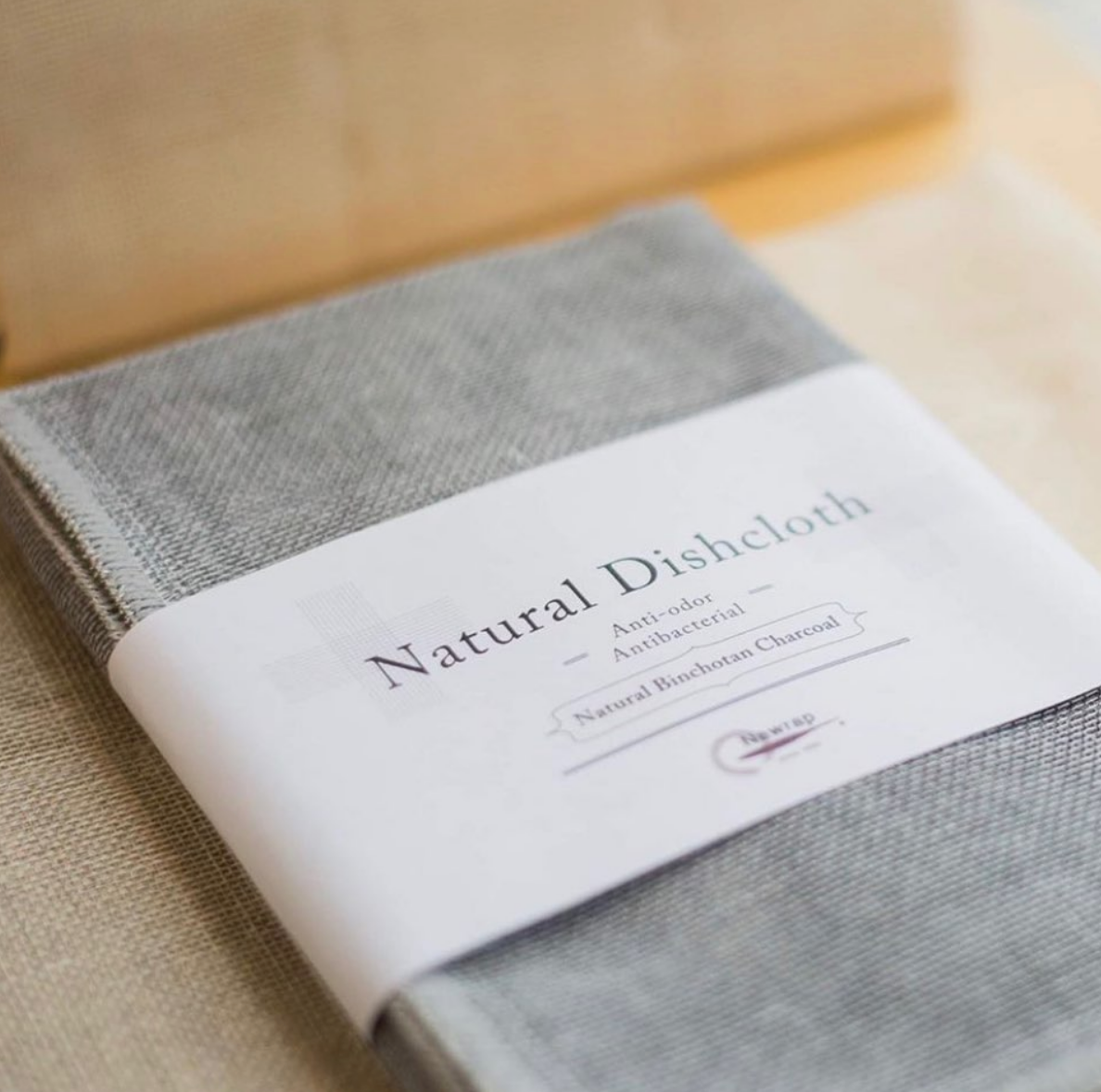 Grey Nawrap dishcloth in its paper band, close view