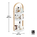 An Umbra cosmetics organizer featuring a three-tier shelf and makeup brushes with the product name BELLWOOD COSMETIC ORGANIZER.