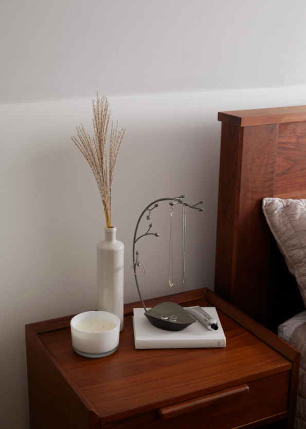 A wooden ORCHID JEWELRY STAND from Umbra with an orchid on it.