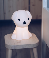 Snuffy First Light Lamp, a small white dog, sitting on top of a stool. 
(brand name: Mr Maria)