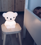 A baby is peacefully sleeping next to a Boris First Light Lamp, a Mr Maria nightlight.