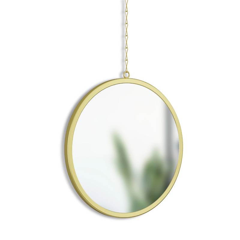 An Umbra DIMA ROUND MIRROR, SET OF THREE hanging from a chain on a wall.