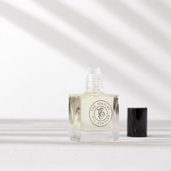 Perfume oil bottle with its cap removed in soft light and shadow